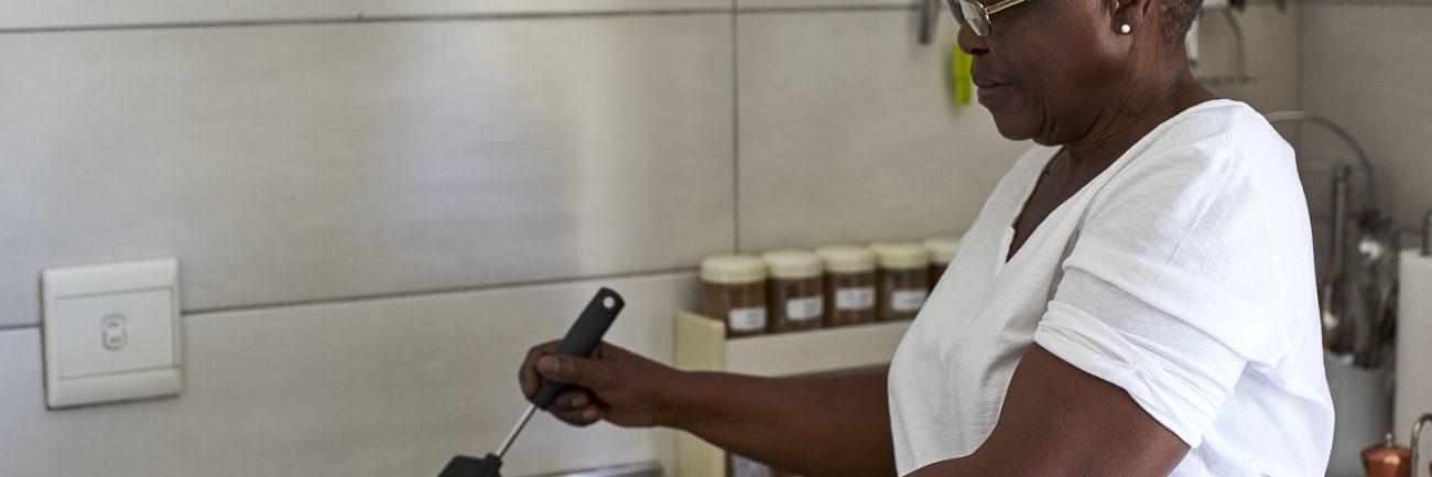 Senior woman cooking at gas stove in kitchen senior-woman-cooking-at-gas-stove-in-kitchen