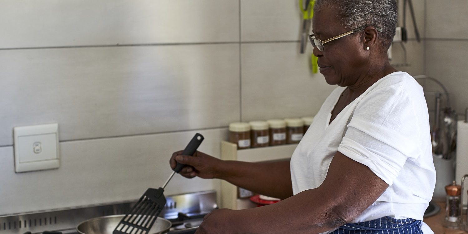 Senior woman cooking at gas stove in kitchen senior-woman-cooking-at-gas-stove-in-kitchen