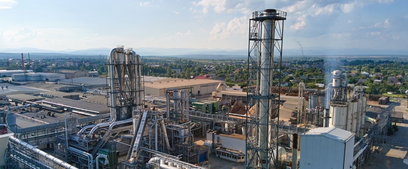 Aerial view of oil and gas refining petrochemical factory with tall refinery plant manufacture structure.