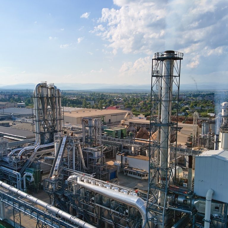 Aerial view of oil and gas refining petrochemical factory with tall refinery plant manufacture structure.
