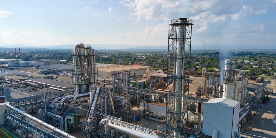 Aerial view of oil and gas refining petrochemical factory with tall refinery plant manufacture structure.