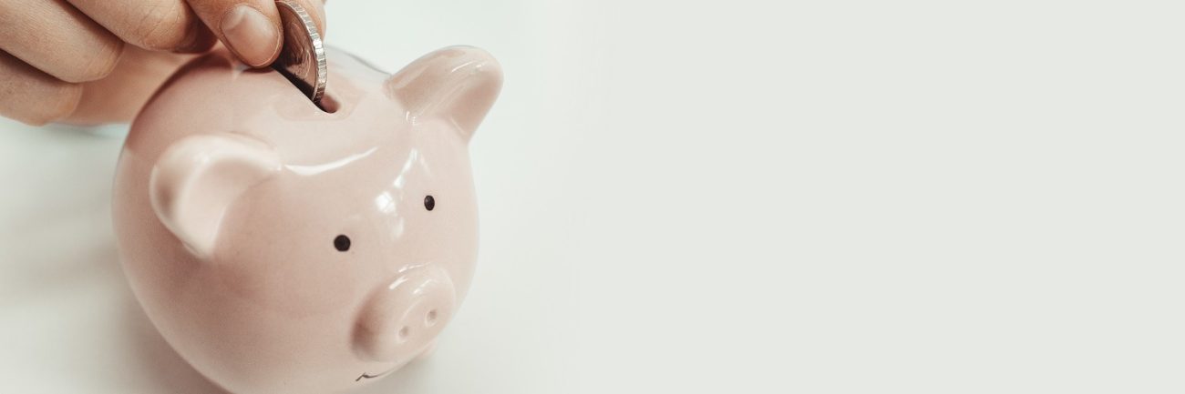 Close up of woman putting a coin inside piggy bank as investment. save money concept Gas natural vehicular
