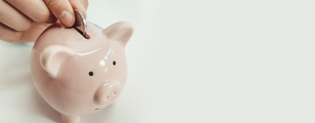 Close up of woman putting a coin inside piggy bank as investment. save money concept Gas natural vehicular