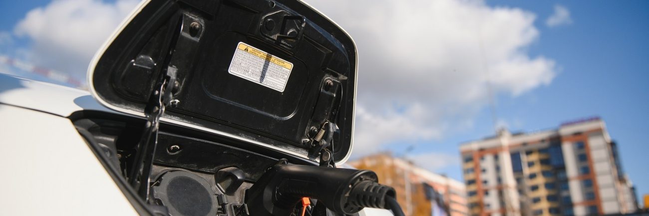 Charging modern electric car battery on the street which are the future of the Automobile, Close up of power supply plugged into an electric car being charged for hybrid . New era of vehicle fuel.