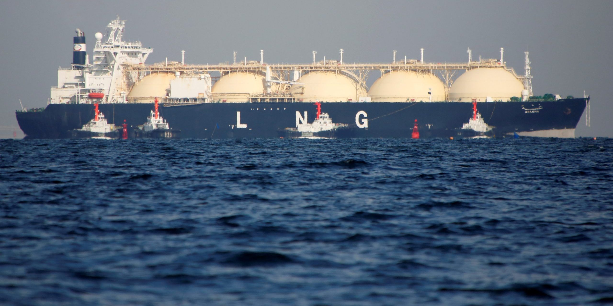 A LNG tanker is tugged towards a thermal power station in Futtsu