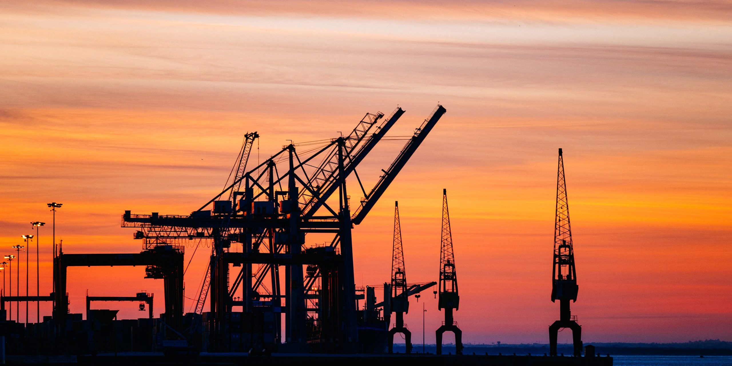 Beautiful silhouette of port machinery during sunset