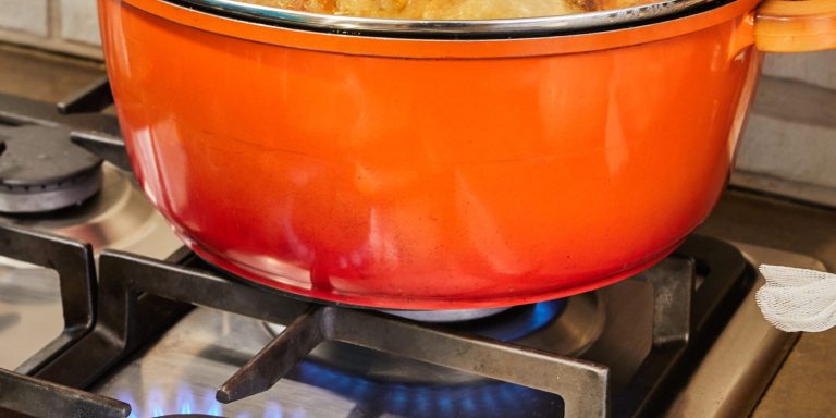 Stuffed zucchini and peppers are cooked in covered pan on gas stove