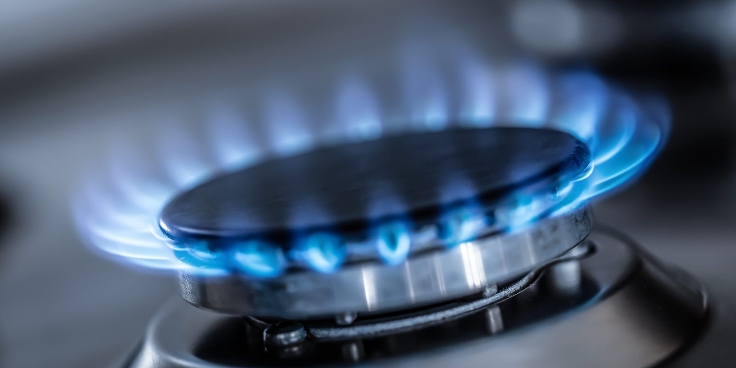 The gas burner burns with the blue flame of a propane butane stove in a home kitchen or hotel restaurant.
