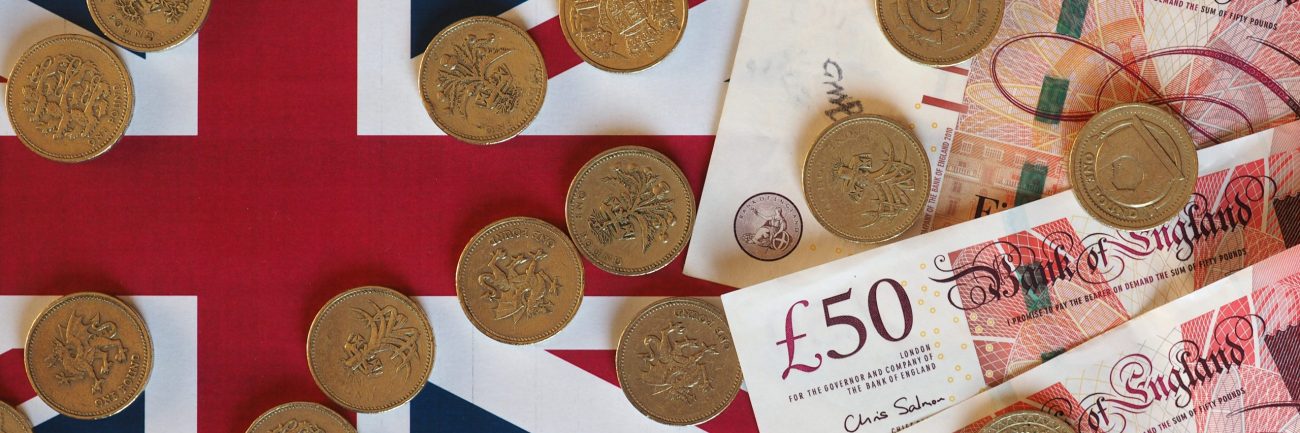 Pound coins and notes, United Kingdom over flag