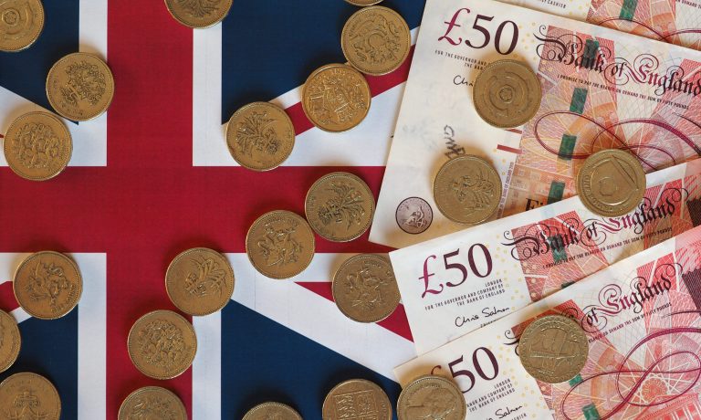 Pound coins and notes, United Kingdom over flag