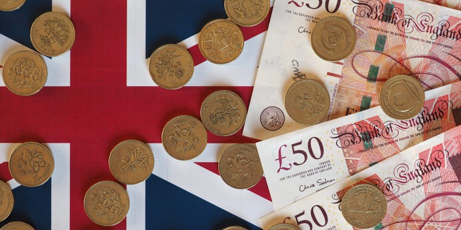 Pound coins and notes, United Kingdom over flag