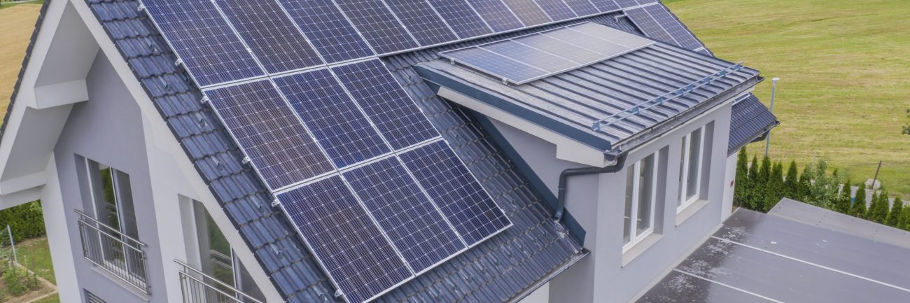 High angle shot of a private house situated in a valley with solar panels on the roof