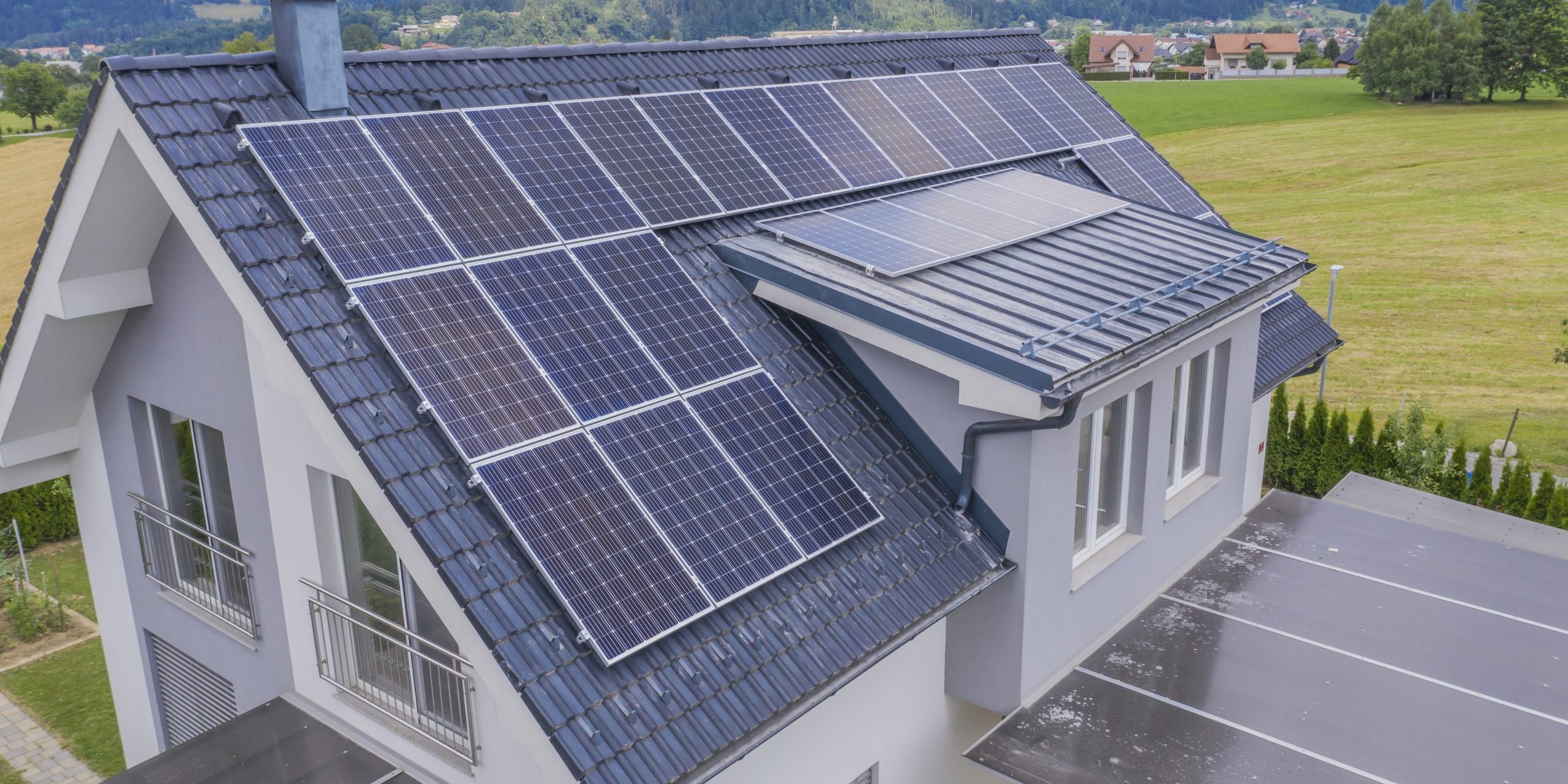 High angle shot of a private house situated in a valley with solar panels on the roof
