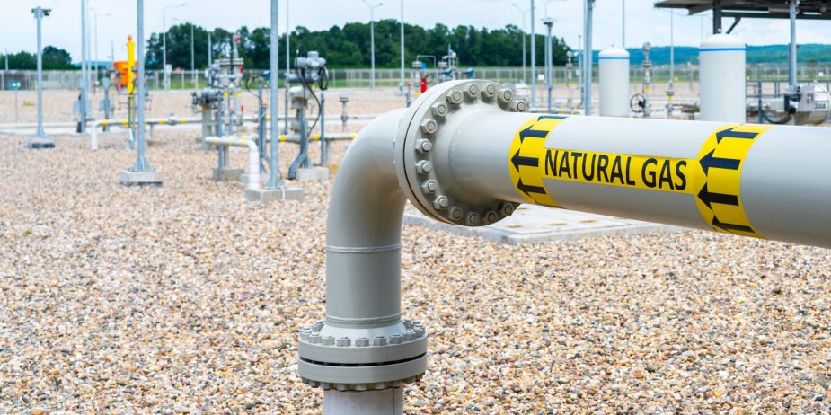 Turn and underground transition of high pressure pipe indicating natural gas and flow direction