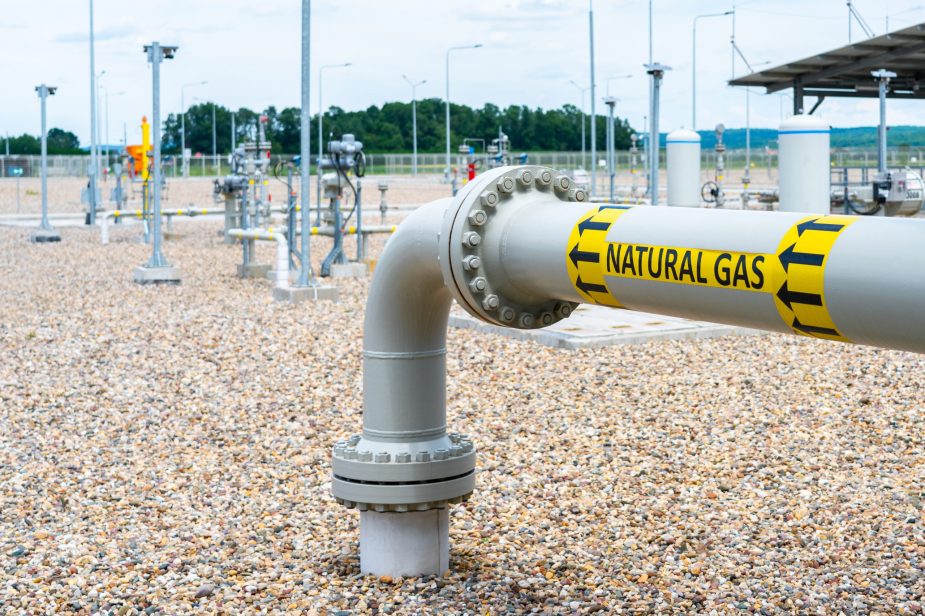Turn and underground transition of high pressure pipe indicating natural gas and flow direction