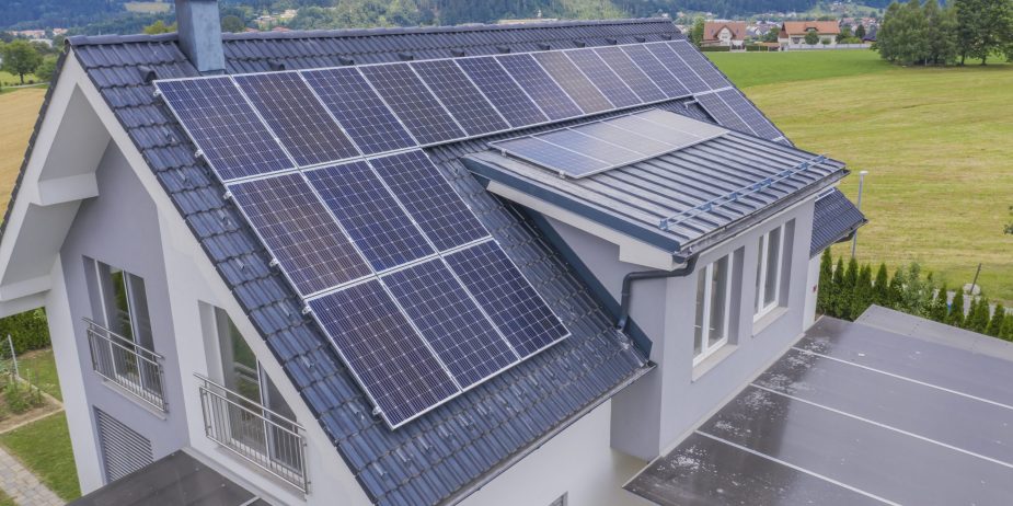 High angle shot of a private house situated in a valley with solar panels on the roof