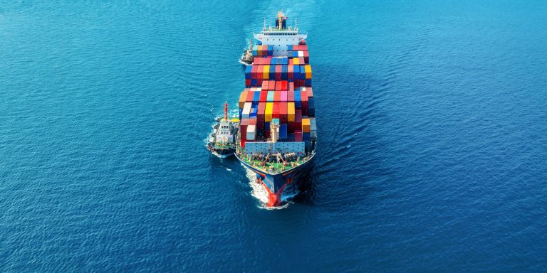 Aerial view of cargo ship with cargo container on sea.
