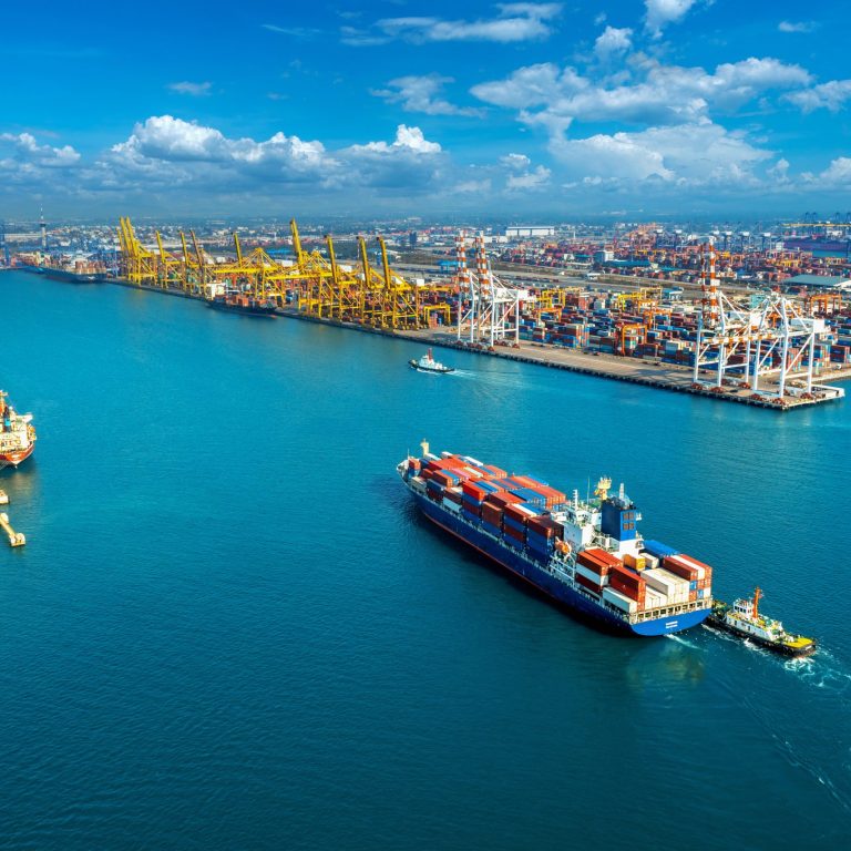 Aerial view of cargo ship and cargo container in harbor.