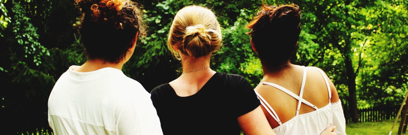 vista-trasera-de-amigos-de-pie-en-el-parque