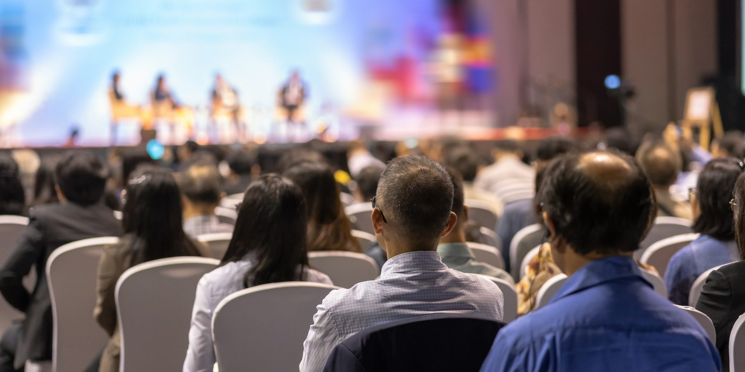 Rear view of Audience listening Speakers on the stage in the con