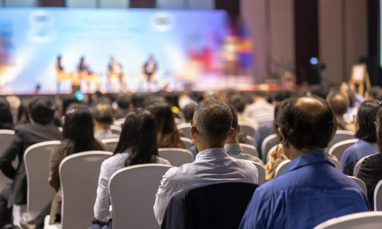 Rear view of Audience listening Speakers on the stage in the con