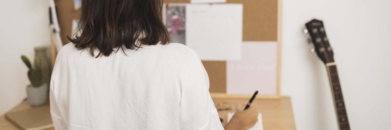 vista-posterior-mujer-escribiendo-en-un-cuaderno vista-posterior-mujer-escribiendo-en-un-cuaderno