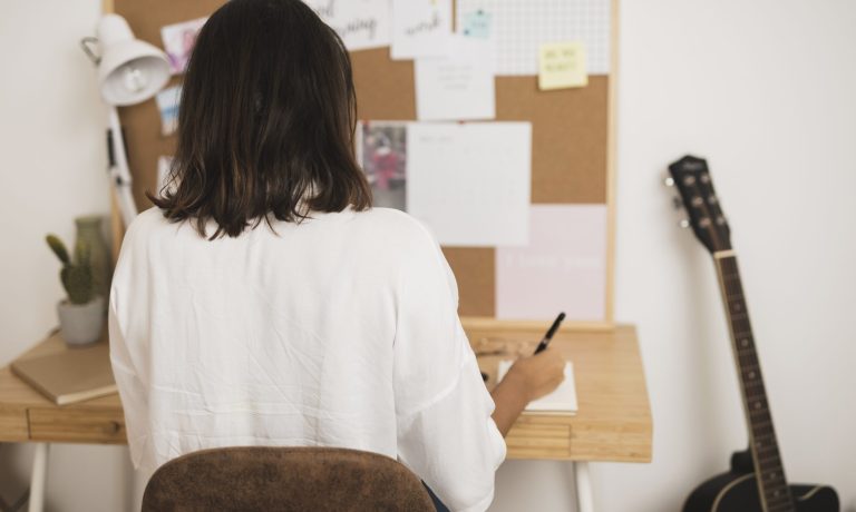 vista-posterior-mujer-escribiendo-en-un-cuaderno vista-posterior-mujer-escribiendo-en-un-cuaderno