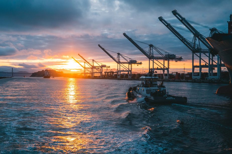 Panoramic shot of oil rigs at sea with a beautiful sunset in the background, under cloudy sky
