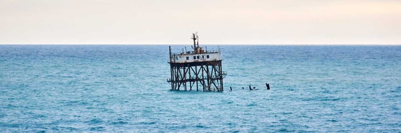 seascape with a rickety structure on the stilts of an aquaculture farm