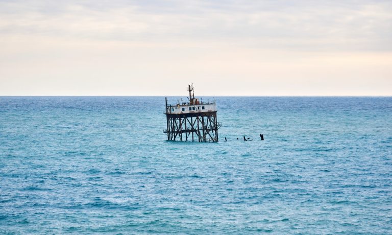 seascape with a rickety structure on the stilts of an aquaculture farm
