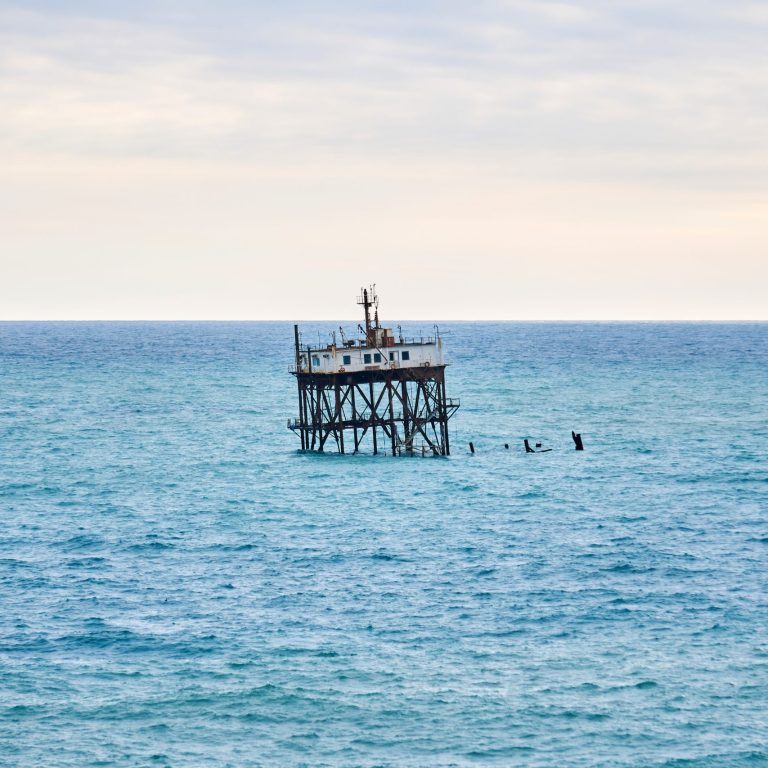 seascape with a rickety structure on the stilts of an aquaculture farm