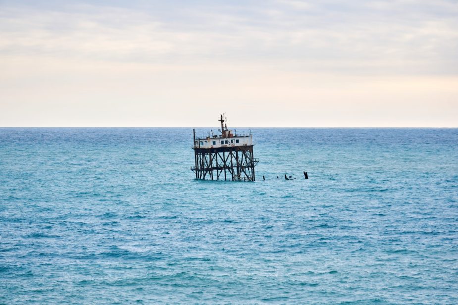 seascape with a rickety structure on the stilts of an aquaculture farm