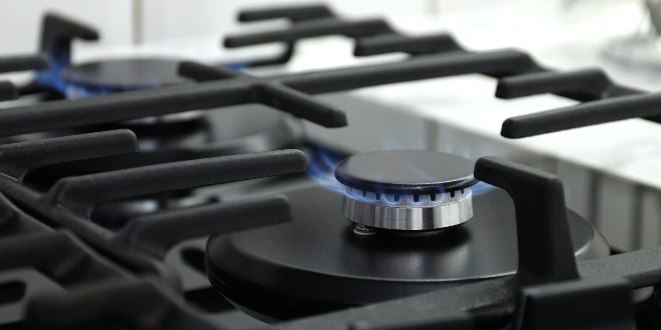 Closeup shot of blue fire from domestic kitchen stove top. Gas cooker with burning flames of propane gas. Industrial resources and economy concept.