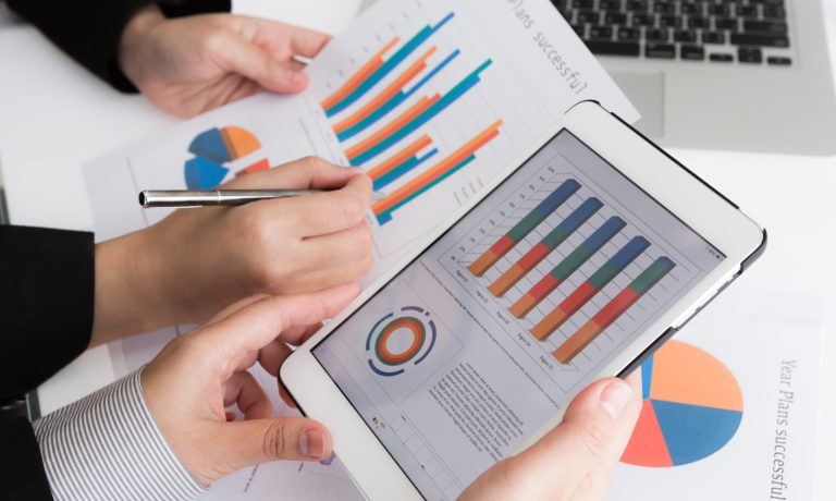 Close-up of business team using digital tablet with financial d