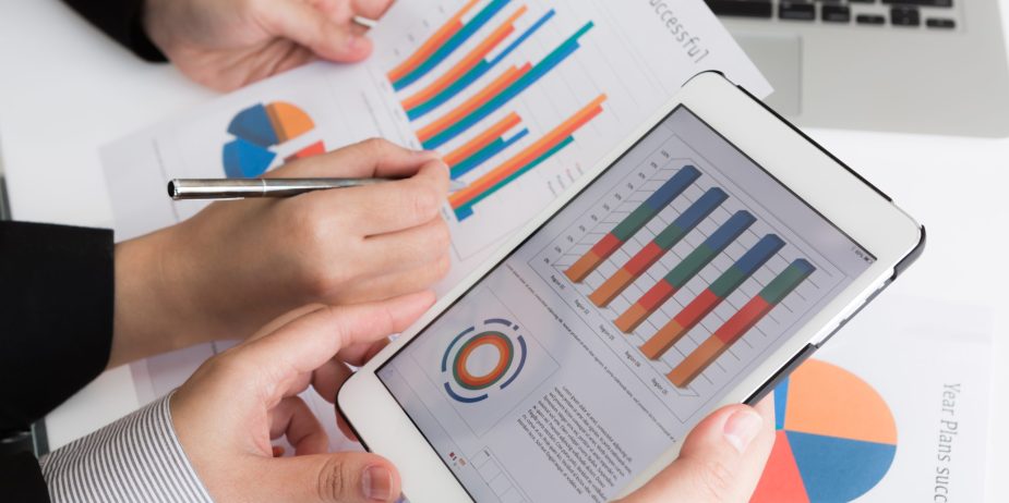 Close-up of business team using digital tablet with financial d