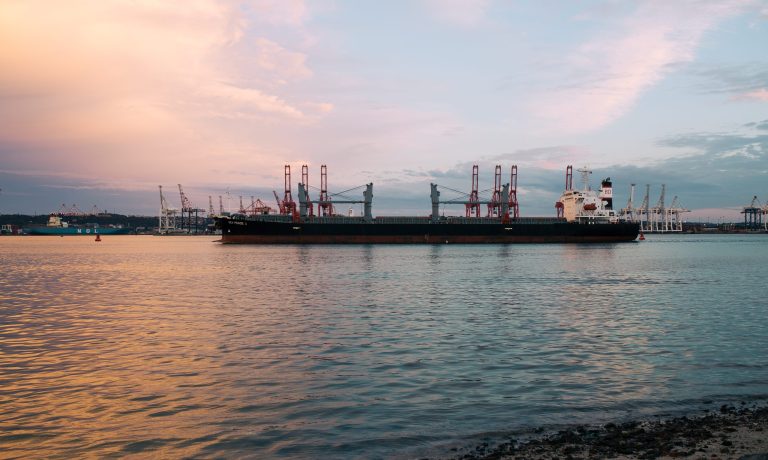 Cargo ship parked at the harbor on a sunny day during sunset