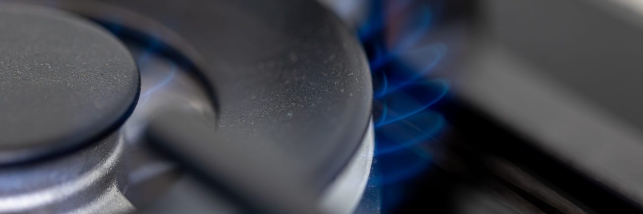 Close-up gas burner. Blue flame. Modern kitchen tech.