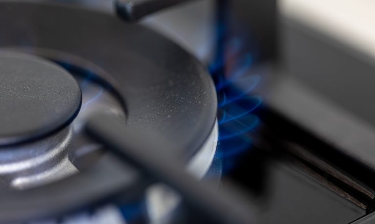 Close-up gas burner. Blue flame. Modern kitchen tech.