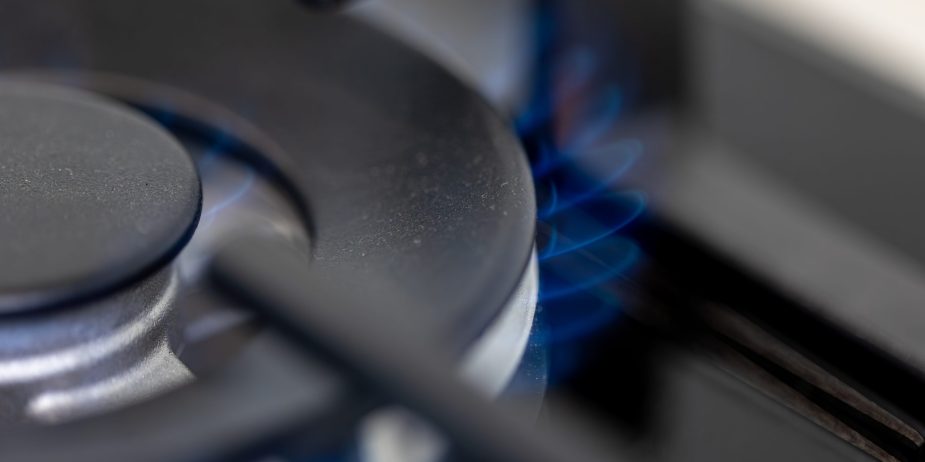 Close-up gas burner. Blue flame. Modern kitchen tech.