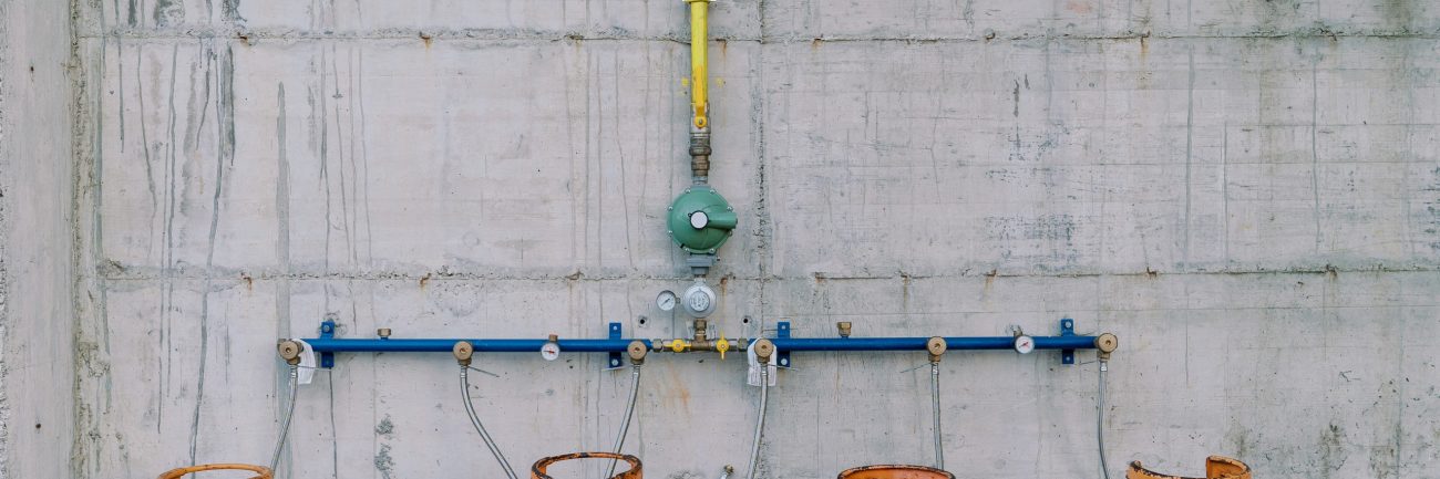Gas cylinders connected to pipes on a concrete wall