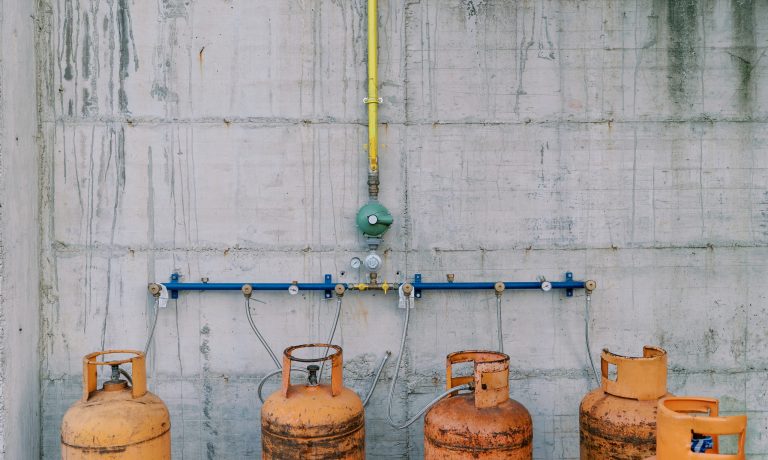 Gas cylinders connected to pipes on a concrete wall