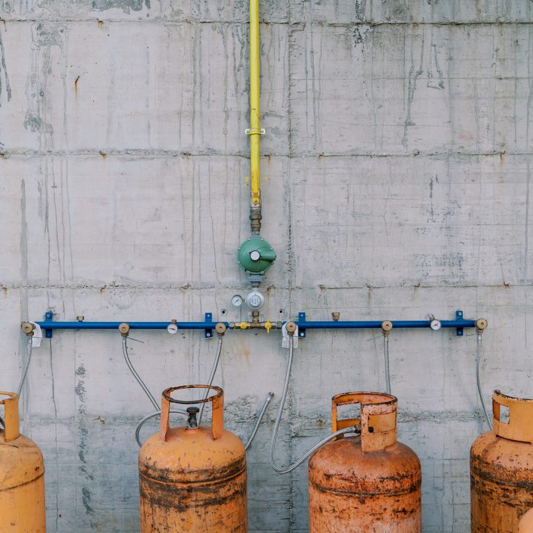 Gas cylinders connected to pipes on a concrete wall