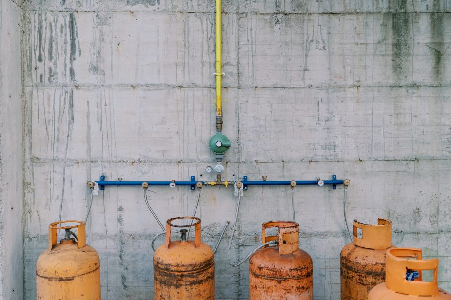 Gas cylinders connected to pipes on a concrete wall
