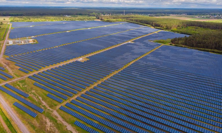 Solar panel produces green, environmentaly friendly energy from the setting sun. Aerial view from drone.