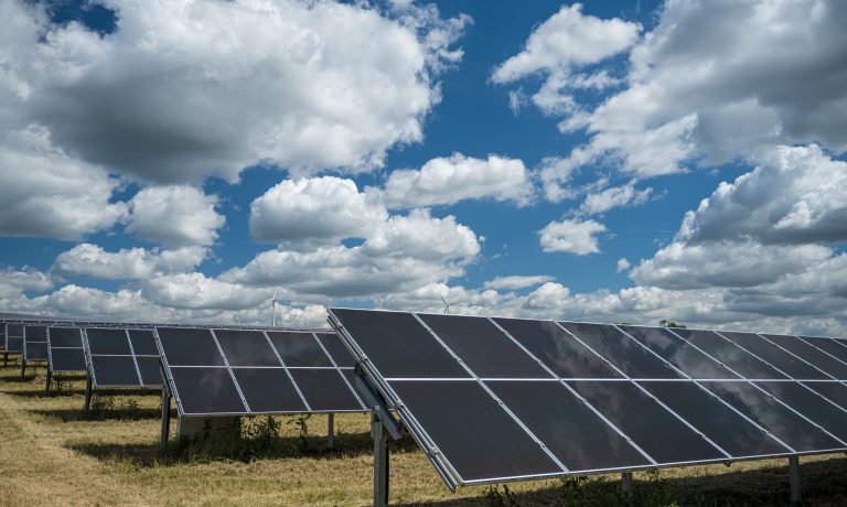 Solar panels used for renewable energy on the field under the sky full of clouds