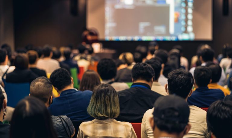 Rear view of Asian audience joining and listening speaker talkin