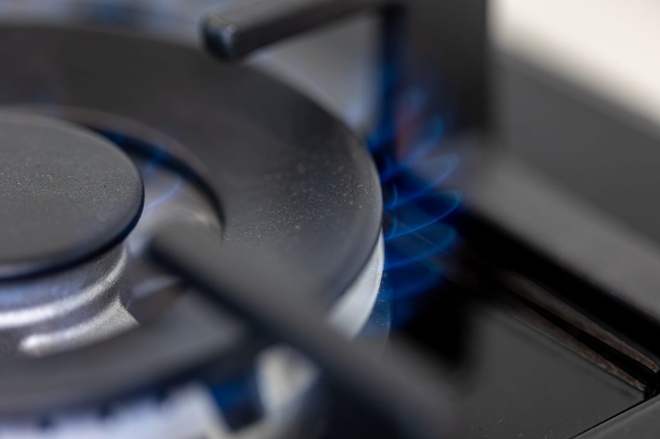 Close-up gas burner. Blue flame. Modern kitchen tech.