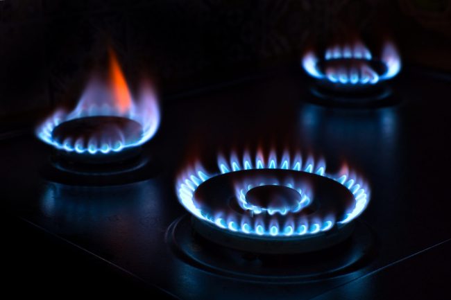 Natural gas burning on the stove. Blue flame. Three burners.