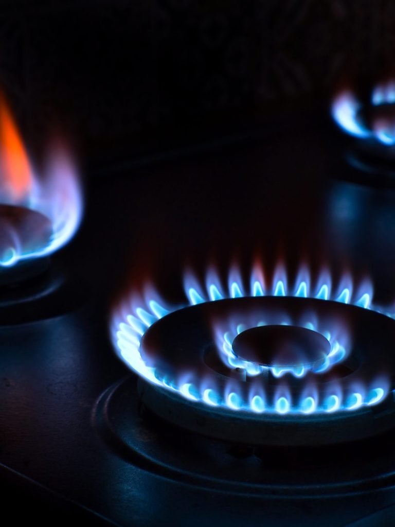 Natural gas burning on the stove. Blue flame. Three burners.