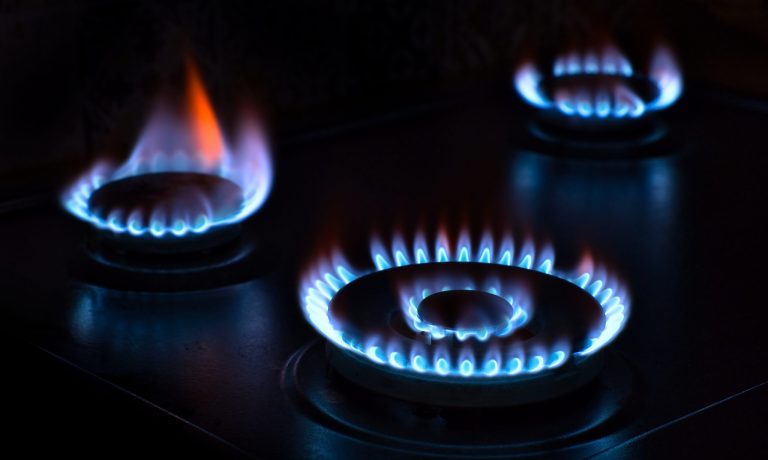 Natural gas burning on the stove. Blue flame. Three burners.